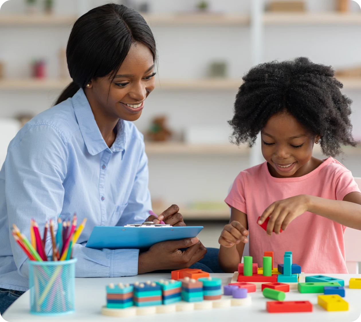 Smiling teacher guides child in learning activity
