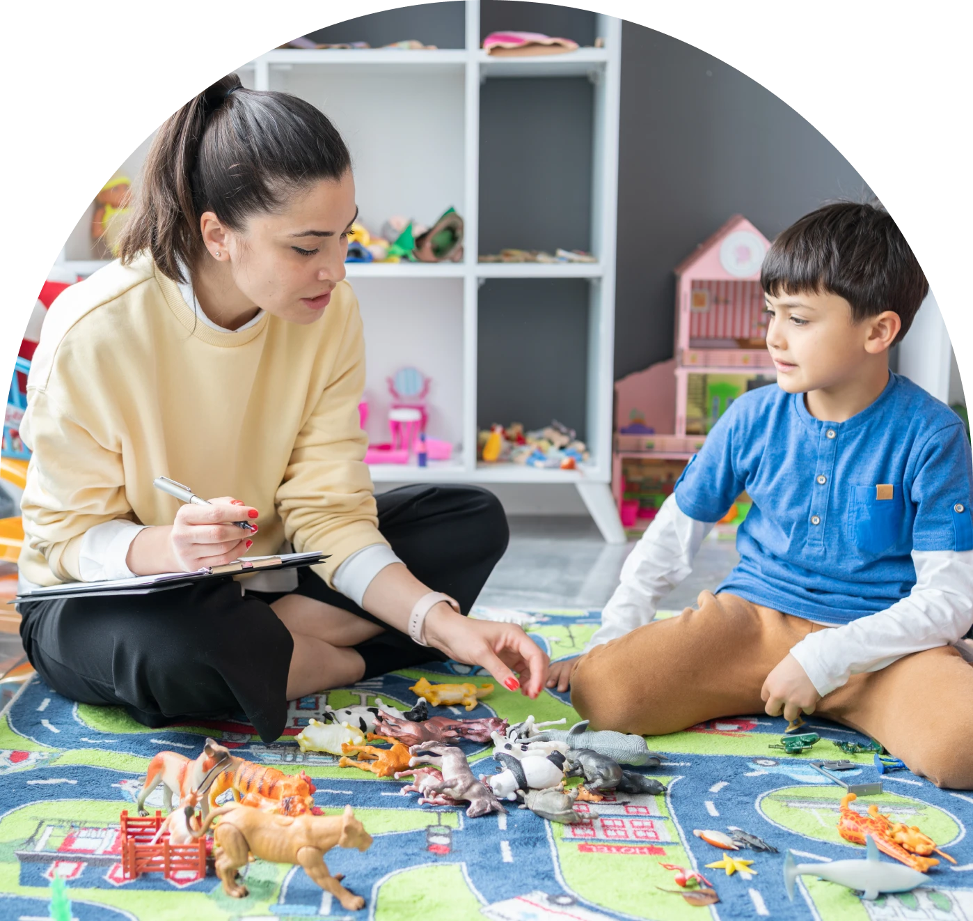 Woman and boy sitting on play mat